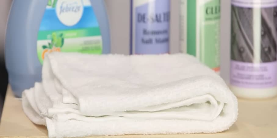 A white microfiber cloth with cleaning and conditioning products on the backing.