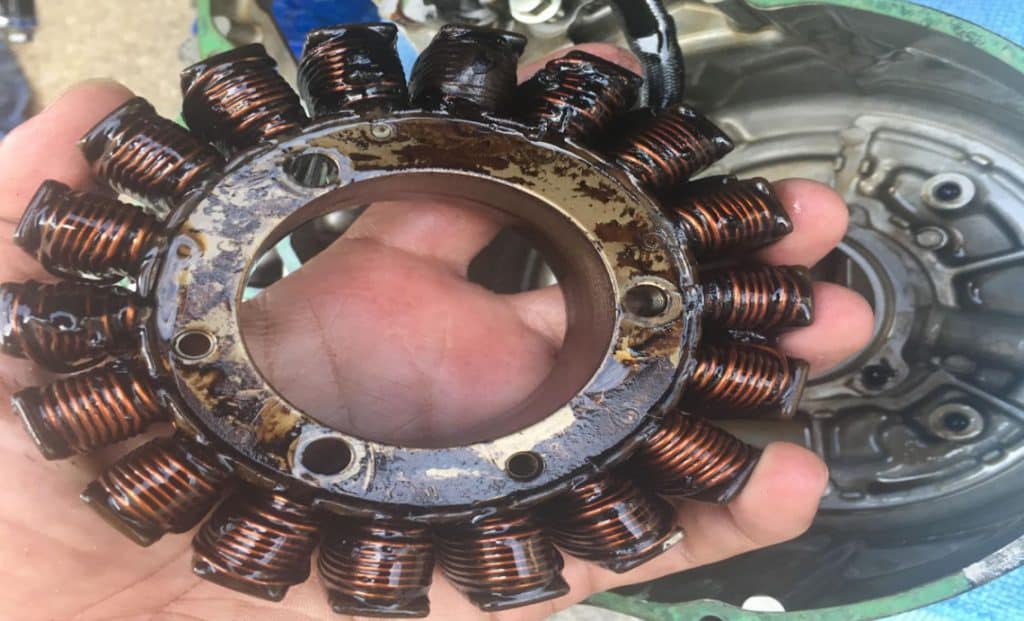 Do Motorcycles Have Alternators? Understand the Modern Electrical Systems and How to Maintain Them Inspecting a motorcycle stator for damage. In this design, the stator bathes in engine oil, but damage is clearly visible on the blackened upper coils.
