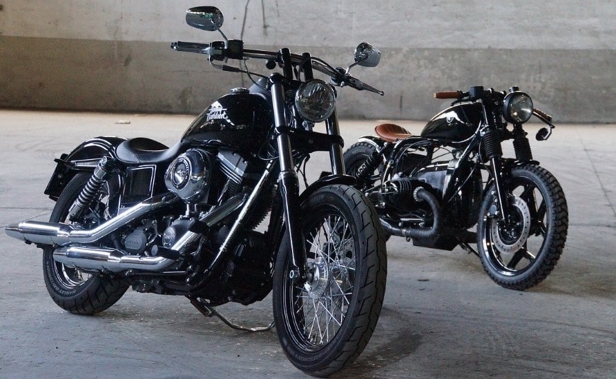 Two bobbers side by side at a bike meet. Each rider has a unique taste, and their bikes certainly reflect that.