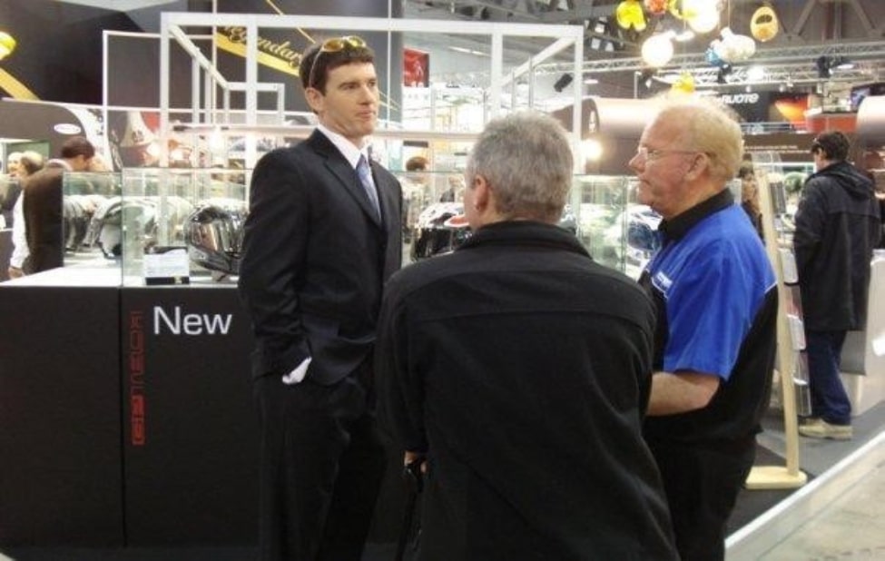 Here, wearing a sharp black suit, with my hands comfortably tucked into my trouser pockets and glasses resting on my head, I stand proudly at the AGV stand during the Milan Exposition in Italy.