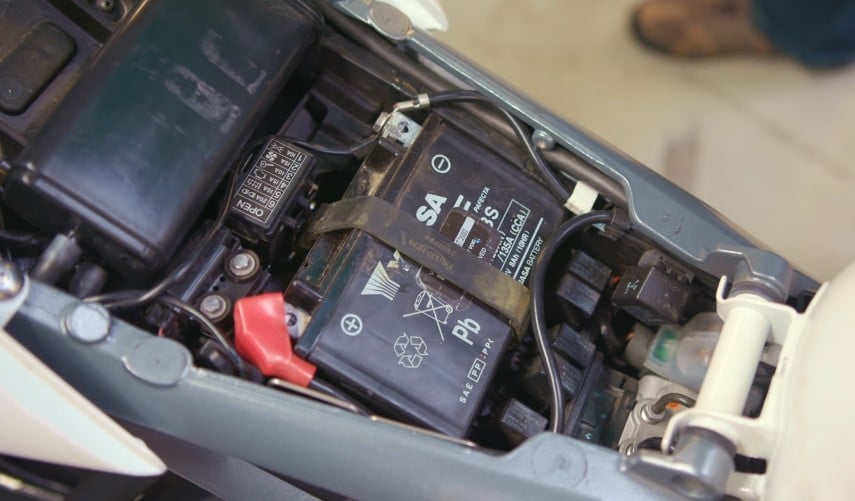 Close-up of a Yuasa AGM 12V 8Ah 135A battery mounted on a Triumph Street Triple motorcycle, ready to power the ride ahead.