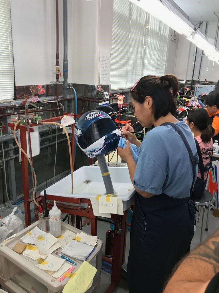 Graphics that are not painted are typically applied as water decals, a painstaking process completed before the helmet undergoes the final clear coat application. Interestingly, Arai entrusts the decal application specifically to women, a choice made due to their observed patience and attention to detail, qualities essential for such intricate work.