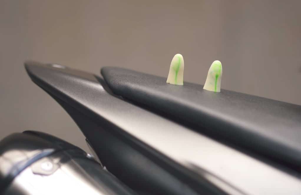 A pair of vibrant, soft foam earplugs rests gently on the Yamaha R1 seat.