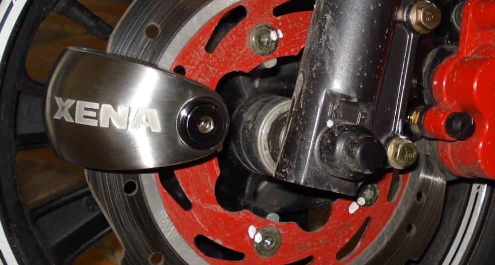 The Xena XX6 disc lock, equipped with a 20dB alarm and Bluetooth control, easily fastens through the rear disc rotor. Its loud alarm serves as a deterrent, likely to scare away any potential thief.