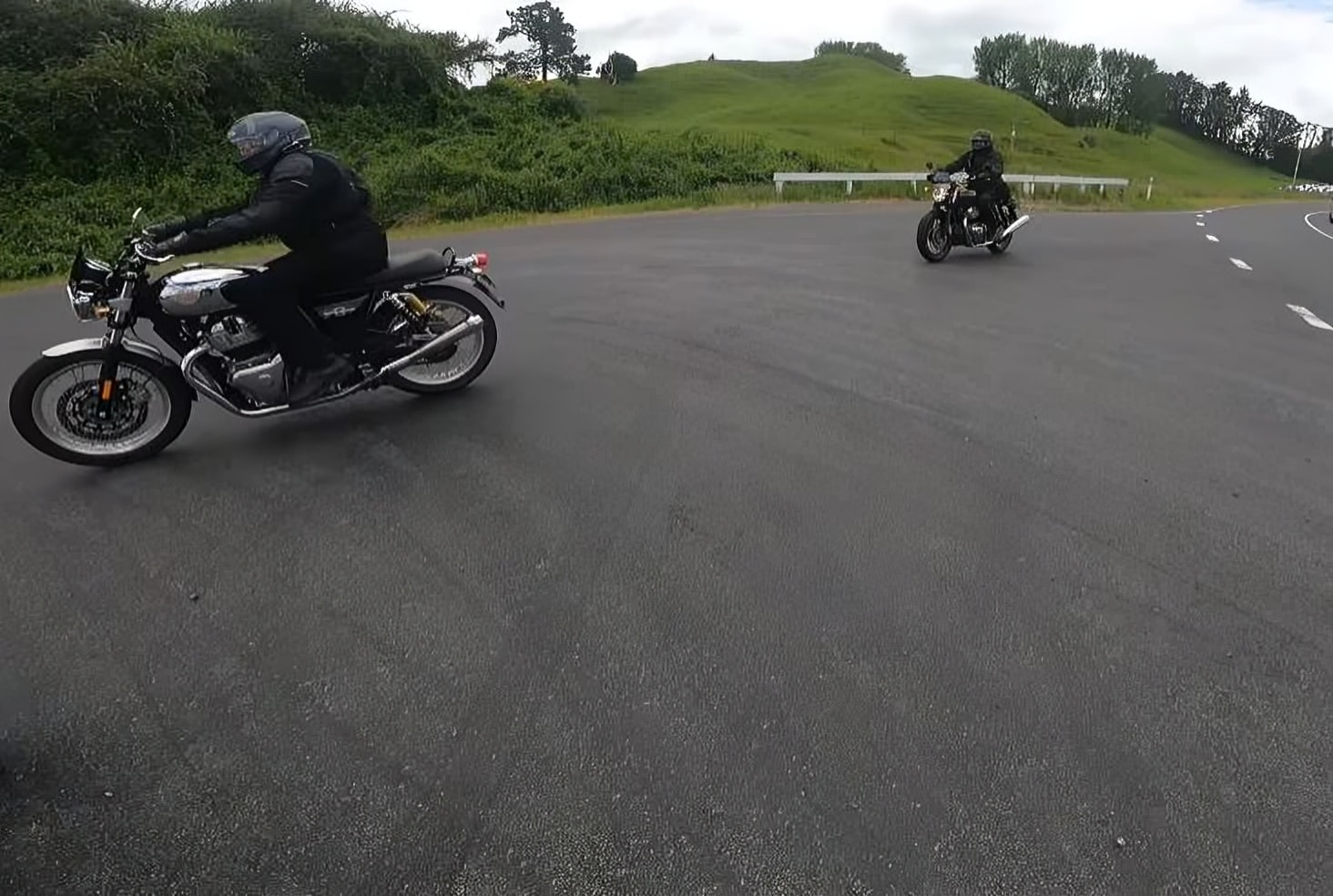 Two motorcyclists riding together, both equipped with Bluetooth 2-way headsets integrated into their helmets, allowing them to communicate effortlessly and even share music while cruising together on the open road.