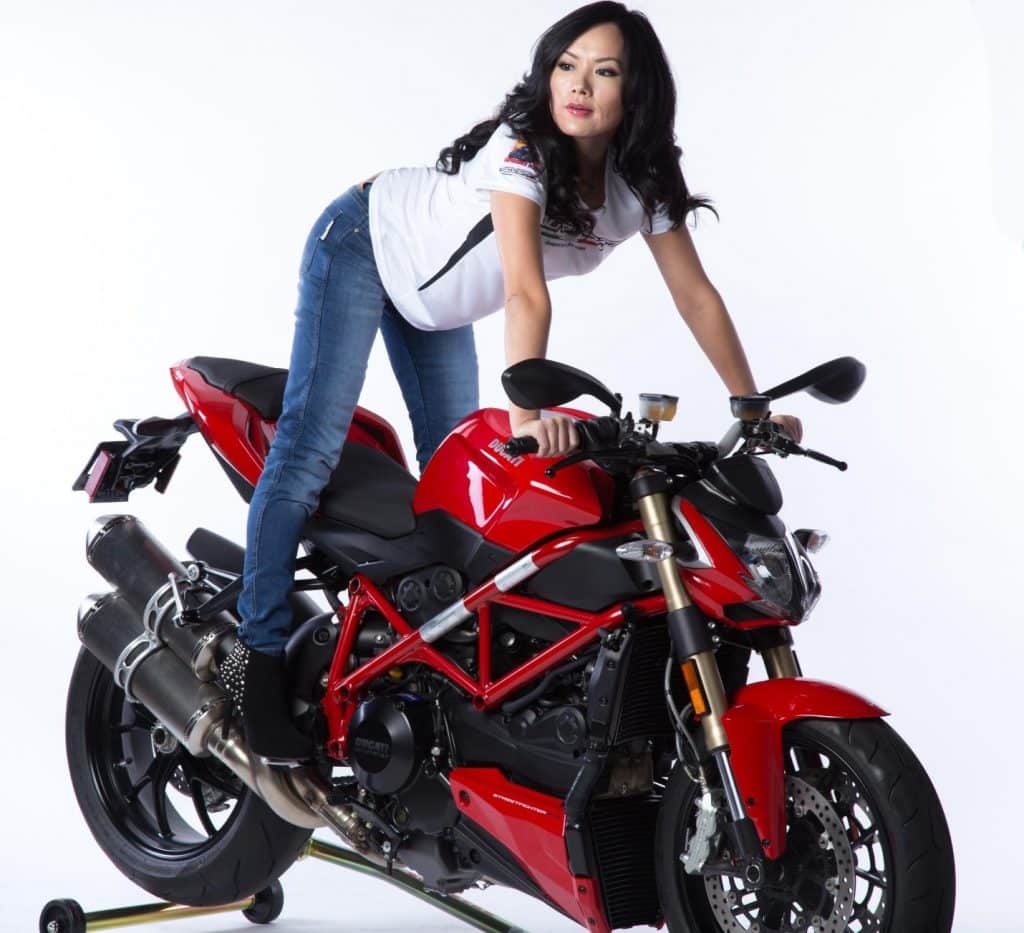 Wearing Kevlar motorcycle jeans, a stunning AGVSPORT model Annie Chiang stands on the pegs of the naked Ducati Streetfighter 848. Despite not conveying an owner or rider persona, the image showcases how real riders can exude both style and safety.