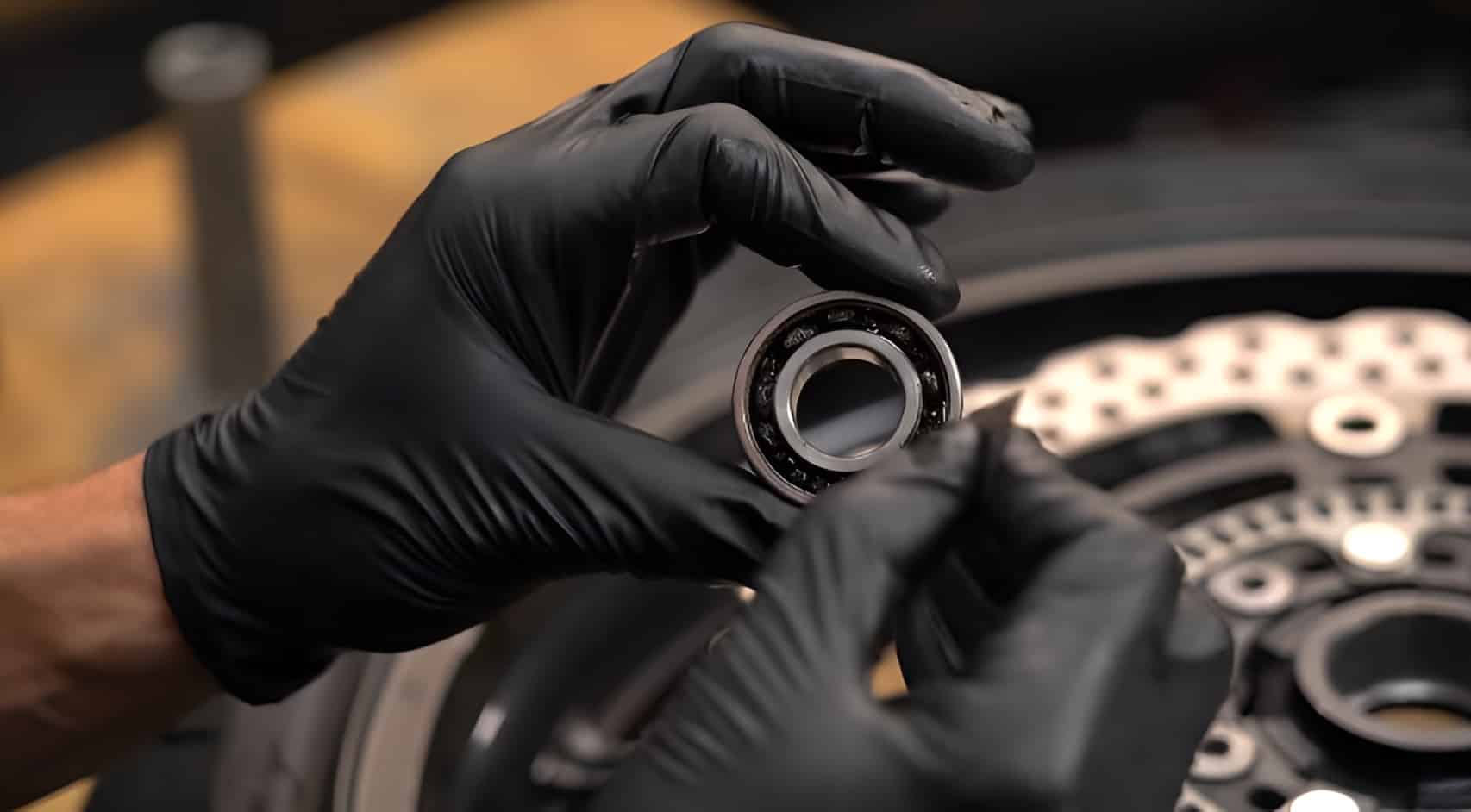 Inspecting a new motorcycle wheel bearing before installation. Checking for smooth rotation and verifying the bearing number to ensure the correct fit for the wheel hub.