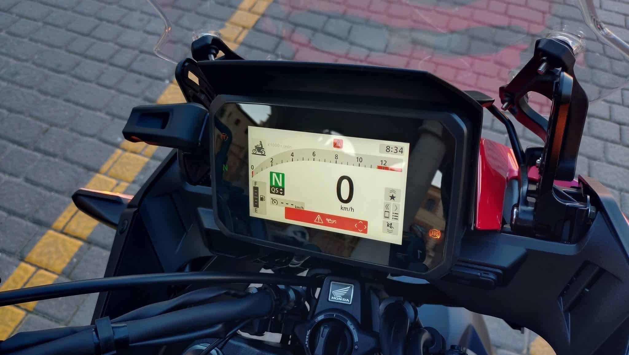 The 2026 Honda CB1000GT's five-inch full-color Thin-Film Transistor (TFT) screen, brightly illuminated with the speedometer, tachometer, gear indicator, and other electronic rider aid information clearly visible against the motorcycle's dark handlebars and windscreen.